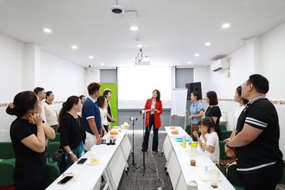 Vũ Hà Trang áo đỏ đứng đầu phòng hướng dẫn học viên thực hành trong workshop