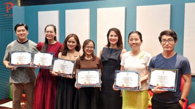 Học viên khoá Luyện giọng ứng dụng đứng thành hàng, cầm giấy hoàn thành khoá tại Đạt Phi Academy