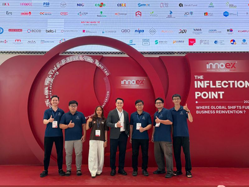 Bảy nhân sự VHITEK chụp ảnh trước backdrop chủ đề The Inflection Point