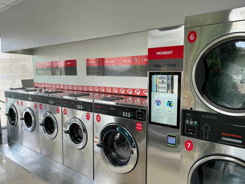 Kiosk thanh toán tự phục vụ đặt giữa dãy máy giặt