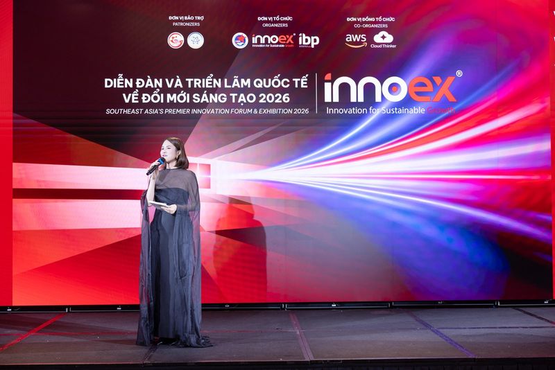 Vũ Hà Trang dẫn chương trình trước backdrop Diễn đàn và Triển lãm Quốc tế về Đổi mới Sáng tạo 2026